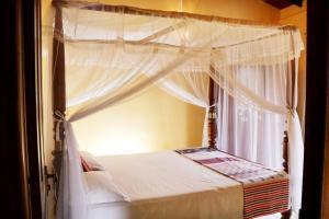 una camera con letto a baldacchino e finestra di Ariyadasa Guest House a Galle