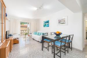 ein Wohnzimmer mit einem Tisch und einem Sofa in der Unterkunft APARTAMENTO LOS GIRASOLES in Alcúdia