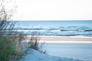 a beach with snow on the sand and the ocean w obiekcie Apartament Gosia w Rogowie