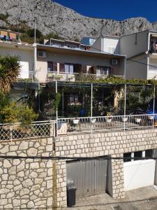 a building with a stone wall and a fence at Apartments Niko in Omiš