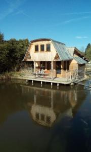 a house on a dock on a body of water at Cabanes de moon in Moon-sur-Elle