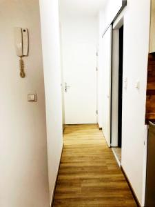 a hallway of an apartment with white walls and wooden floors at LINZ bellavista Studio-Apartment Landstraße in Linz