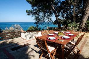a wooden table with a bowl of fruit on a patio at Villa Agave - SeaFront - Pool Kids - BBQ in Santa Flavia