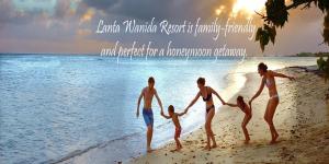 a family playing on the beach at sunset at Lanta Wanida Resort in Ko Lanta