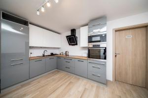 a kitchen with stainless steel appliances and a wooden door at 6 Cities Rooms in Warsaw
