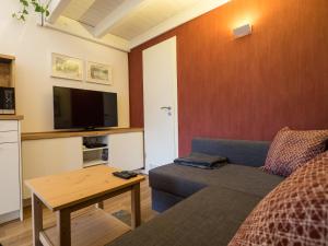 uma sala de estar com um sofá e uma televisão de ecrã plano em Gemütliche Ferienwohnung im Reihenhaus em Hochheim am Main