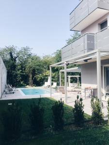 a house with a swimming pool and a balcony at Pove 2.4 Hotel in Pove del Grappa