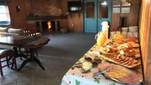 a table with plates of food on it with a fireplace at Pousada Fazenda A CASA DO MORRO in Cambara do Sul