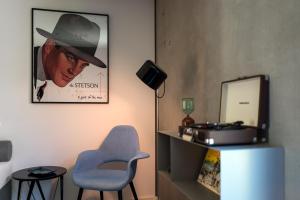 a room with a blue chair and a picture of a cowboy at Das Eckert - Lifestyle Design Hotel & Fine Dining bei Basel (Grenzach) in Grenzach-Wyhlen