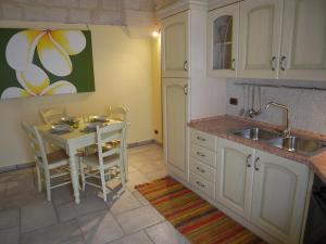 una cucina con un tavolino e un lavandino di Casa Nina by RENTHOUSESALENTO - a 50 m dal mare a San Foca