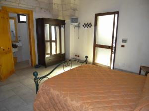 una camera con un letto in una stanza con finestre di Casa Nina by RENTHOUSESALENTO - a 50 m dal mare a San Foca