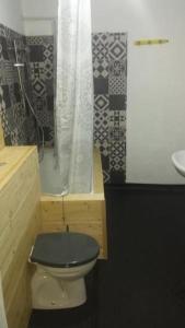 a bathroom with a toilet with a black seat and a sink at Art Studio in Braşov