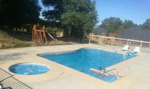 a pool with two people in the water and a playground at Domos Elohim in Pucón