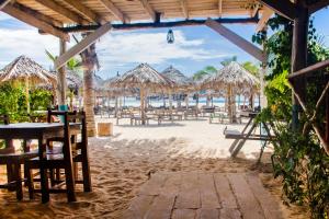 een strand met een stel tafels en rieten parasols bij Kendwa Beach BnB in Kendwa