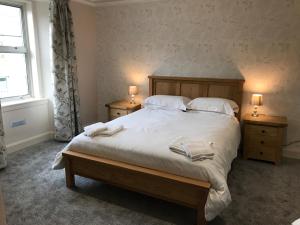 Whisky Capital Inn في دوفتاون: غرفة نوم بسرير كبير مع مواقف ليلتين