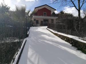 a snow covered driveway to a house with a fence at La terra dei ciliegi tra l'Etna e il mare di Taormina in Piedimonte Etneo