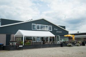 a black building with a white awning in front of it at B&B Manege Groenewoude in Woudenberg