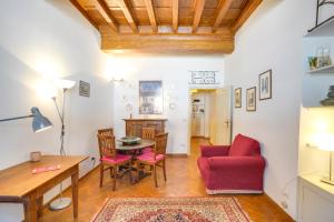 フィレンツェにあるMamo Florence - Palazzo Spinelli Apartmentのリビングルーム(赤いソファ、テーブル付)