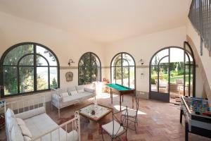 sala de estar con ventanas y mesa de ping pong en Villa di Cabbiavoli, en Castelfiorentino
