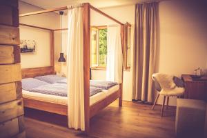 ein Schlafzimmer mit einem Himmelbett und einem Fenster in der Unterkunft Gasthaus Am Ödenturm in Chammünster
