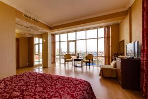 een hotelkamer met een bed en een tafel met stoelen bij Vizit Hotel in Krasnodar