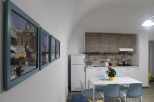 a kitchen with a white table and blue chairs at La Casetta di Anna in Capri