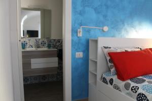 a bedroom with a sink and a bed with a red pillow at La Casetta di Anna in Capri
