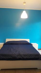 um quarto azul com uma cama com uma parede azul em B&B RosAngelo em Mirabella Imbaccari