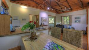 a kitchen and living room with a table and chairs at Crater Lakes Rainforest Cottages in Yungaburra