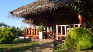 a straw hut with a table and chairs in front of it at Salt Lake Cabanas & Restaurant in Tangalle