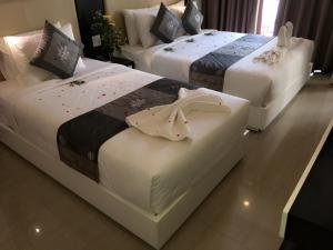 2 Betten in einem Hotelzimmer mit Blumen darauf in der Unterkunft Muine Sports Hotel in Mui Ne