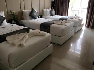 a group of four beds in a room at Muine Sports Hotel in Mui Ne