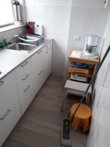 a kitchen with a mop on the floor next to a sink at Dakstudio Met Reuze Zonneterras in Middelkerke