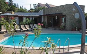 a swimming pool in front of a house at Adler Hotel & Wellness in Tihany