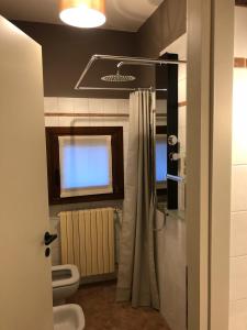 ein Bad mit einem Duschvorhang und einem WC in der Unterkunft Casa 774 in Passirano