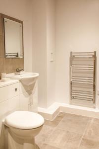 bagno bianco con servizi igienici e lavandino di Luxury Apartments Newcastle a Newcastle upon Tyne