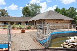 a building with a pool in front of a house at Black Swan Guesthouse in Maseru