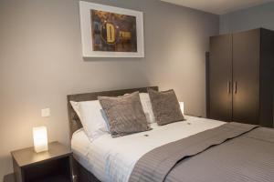 a bedroom with a bed with two lamps on it at Luxury Apartments Newcastle in Newcastle upon Tyne