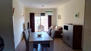 een keuken en een woonkamer met een tafel en stoelen bij Albufeira Premium Apartment in Albufeira