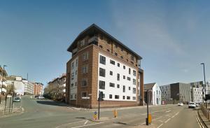 a tall brick building on a city street at Luxury Apartments Newcastle in Newcastle upon Tyne