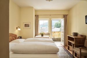 - une chambre avec 2 lits et une fenêtre dans l'établissement Hotel Post Mauterndorf OG, à Mauterndorf