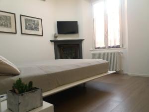 a bedroom with a bed and a tv on the wall at Le Quinte del Duomo in Como