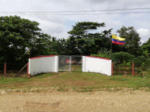 a flag and a fence with a gate and a flag at Aparta-Hotel LENEMBERGER in Puerto Asís