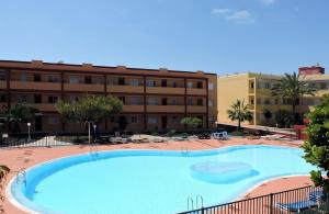 una grande piscina di fronte a un edificio di Caleta Relax - Apartamento Fuerteventura Apartment a La Oliva