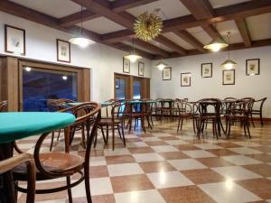 une salle à manger avec des tables et des chaises et un sol en damier dans l'établissement Residence Borgo al Sole, à Sappada