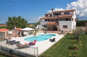 a woman sitting in a chair in front of a house at Villa Kimberly in Rovinj
