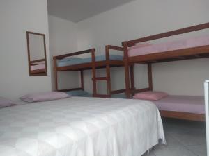 a bedroom with two bunk beds in a room at Suítes Eu in Caraguatatuba