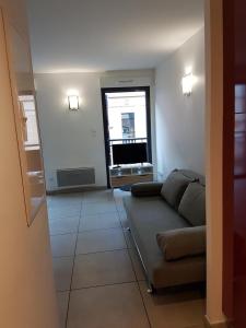 uma sala de estar com um sofá e uma janela em 202 - Appartement Duplex Moderne - Jeanne d'Arc, Toulouse em Toulouse