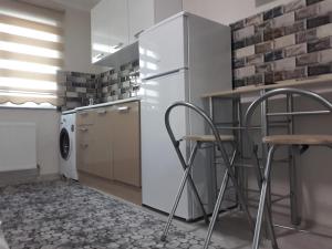 a kitchen with a refrigerator and two bar stools at Moonlight pansiyon in Erzincan +13 photos