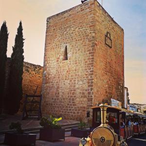 a small train in front of a brick building at Casa Rural El Arcediano in Baeza